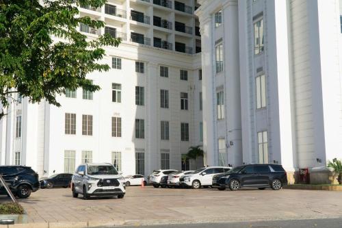 a large white building with cars parked in front of it at Gold Apartment With Sea View In Da Nang Bay in Da Nang