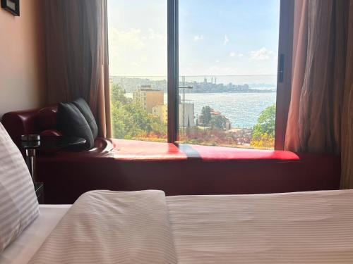 a bedroom with a window looking out at the water at Hotel Xperience in Jounieh