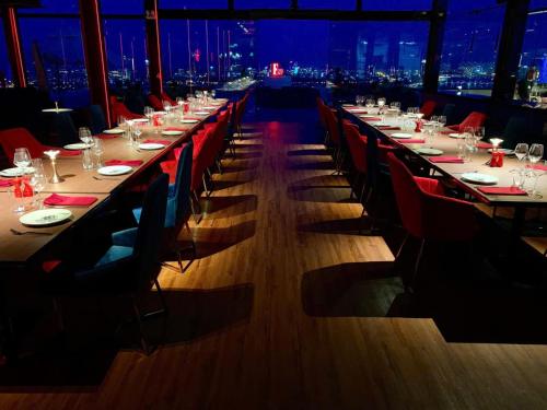 a long dining room with long tables and chairs at Gold Apartment With Sea View In Da Nang Bay in Da Nang