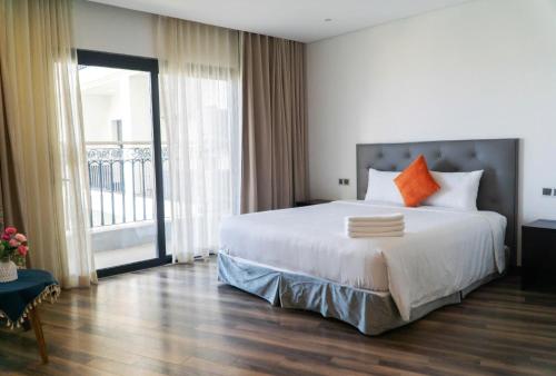 a bedroom with a large bed and a large window at Gold Apartment With Sea View In Da Nang Bay in Da Nang