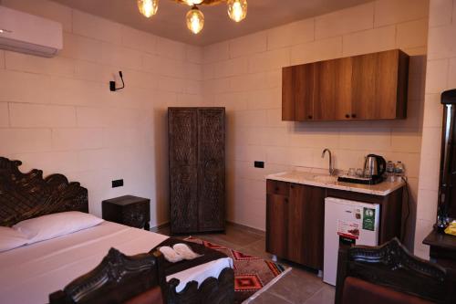 a bedroom with a bed and a kitchen with a sink at De MARİA KONAĞI in Mardin