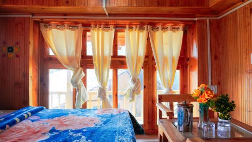 a bedroom with a bed and a window with curtains at Himalayan Homestay Gadagusain in Jibhi
