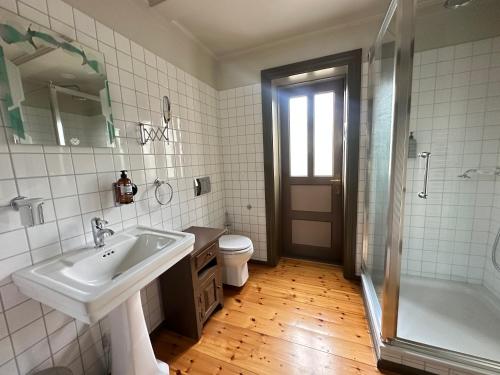 a bathroom with a sink and a shower and a toilet at Gamla Apótekið - The Old Pharmacy - Birta Rentals in Akureyri