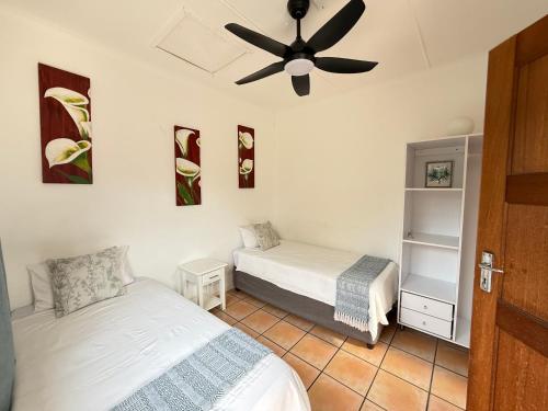 a bedroom with two beds and a ceiling fan at JJs At The Sea in Margate