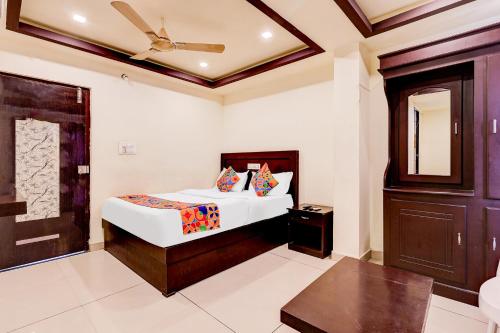 a bedroom with a white bed and a brown door at FabHotel Alfa in Vijayawāda