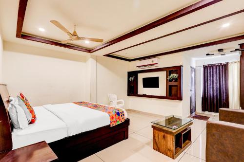 a bedroom with a bed and a tv and a couch at FabHotel Alfa in Vijayawāda