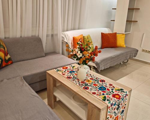 a living room with a table with a vase on it at Apartmán Frida in Zvolen