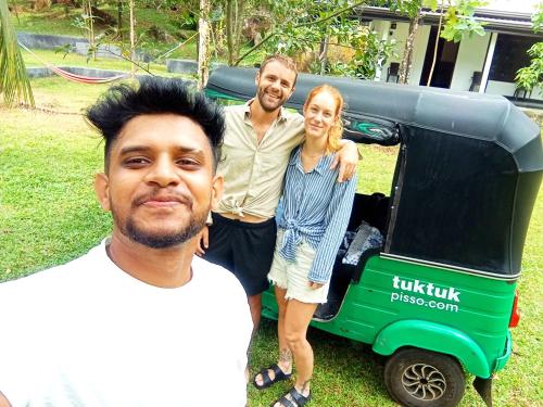 a group of three people standing next to a golf cart at Dhunhill Garden in Avissawella