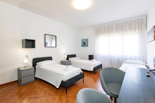 ein Zimmer mit drei Betten und einem Tisch und Stühlen in der Unterkunft Ampia stanza moderna Venezia a 10 minuti in Venedig