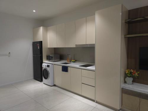 クアラルンプールにあるQuill KLCC Suites By City Homeのキッチン(白いキャビネット、洗濯機、乾燥機付)
