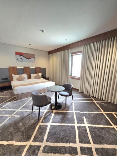 a hotel room with a bed and a table and chairs at How inn Hotel in Al Madinah