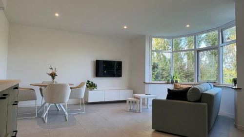 a living room with a couch and a table at B&B Ztrand in Oudesluis