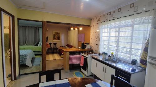 a kitchen with a sink and a living room at Refugio na Natureza in Santo Antônio do Pinhal