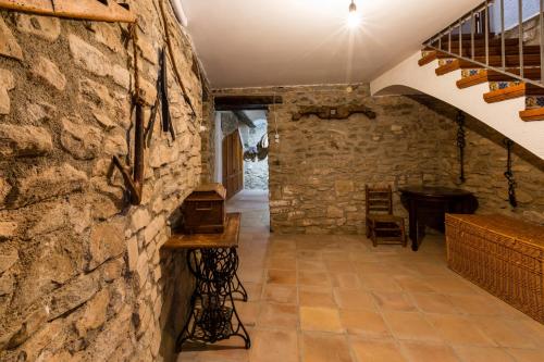 a room with a stone wall and a staircase at Casa Joan de Fontsagrada in Fontsagrada