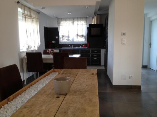 a kitchen and dining room with a wooden table at la menuiserie in Jeuxey