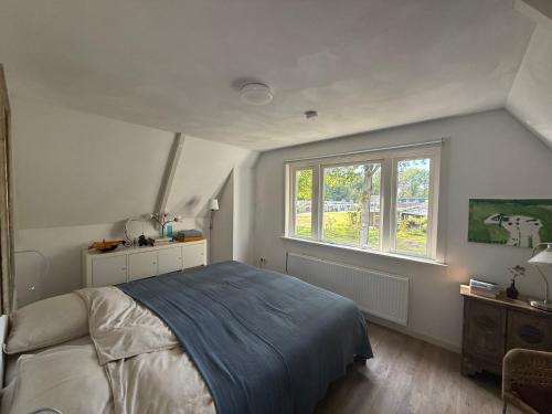 una camera da letto con un letto grande e una finestra di B&B de Wielewaal 