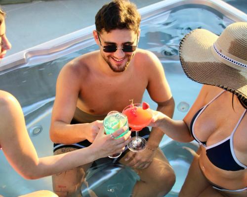 a man and two women in a swimming pool drinking cocktails at Hotel Xperience in Jounieh