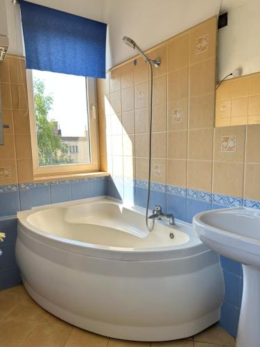ein Badezimmer mit Badewanne und Waschbecken in der Unterkunft Apartament na Pogodnie in Stettin