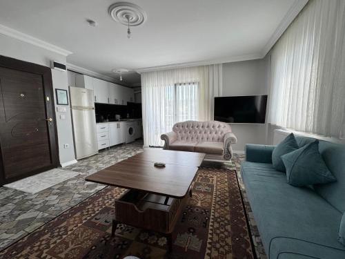 a living room with a blue couch and a table at Lina Apart in Arnavutköy