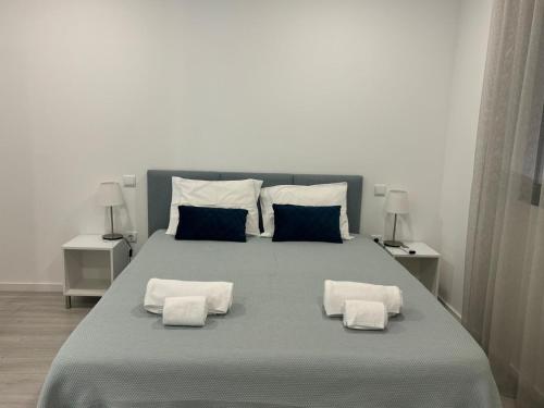 a bedroom with a large bed with two pillows at In Barcelos View Lodge in Barcelos
