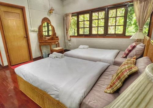 Ban Nam Tok Mae KlangPrivate Forest Cottage in Near Chiang Mai的一间卧室设有两张床、镜子和窗户。