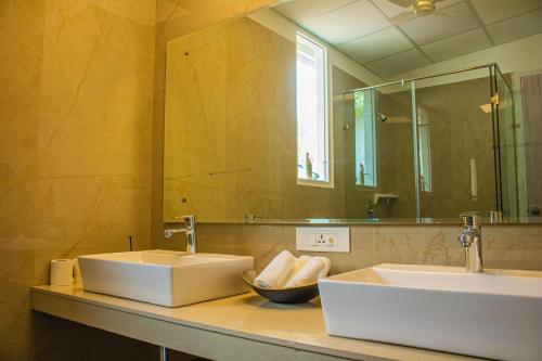 a bathroom with two sinks and a mirror at Baagh-Bohemian 6BHK Farmhouse, Jagatpura, Jaipur in Jaipur