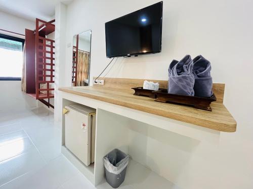a room with a shelf with a tv on a wall at Rendezvous Oldtown Chiangmai in Chiang Mai
