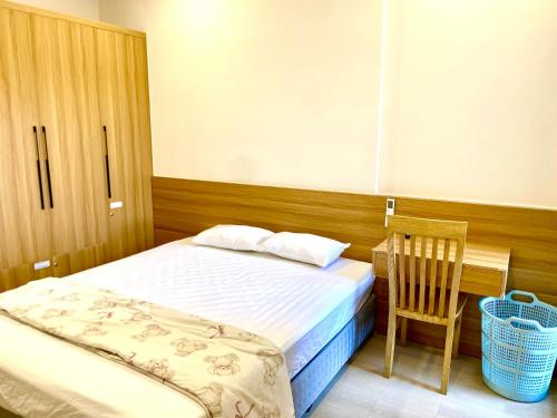 a small bedroom with a bed and a chair at Homestay Dragon Castle Bãi Cháy Hạ Long Quảng Ninh in Ha Long