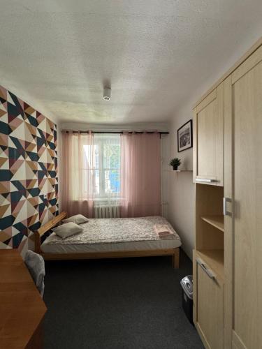 Un dormitorio pequeño con una cama y una ventana. en Dom Gościnny Lublin, en Lublin