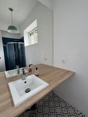 baño con lavabo blanco y encimera de madera en Dom Gościnny Lublin, en Lublin