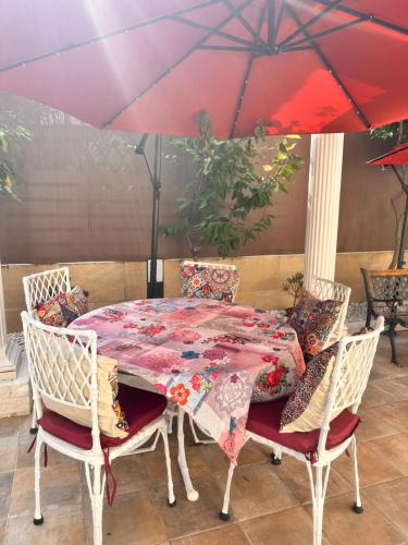 a table and chairs with a red umbrella at Villa IRI Habitación N 4 - Suit con balcón in Pineda de Mar