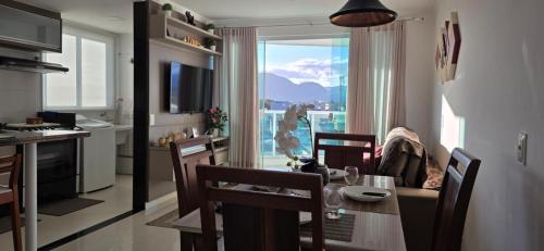 una cucina e una sala da pranzo con tavolo e vista di Vista para as Montanhas a Guarapari