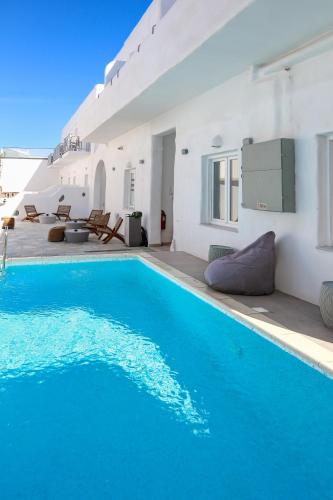 a villa with a swimming pool and white walls at Madaky Hotel in Naousa