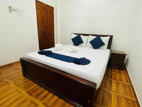 a bed with blue pillows on it in a room at Sholay Villa in Galle