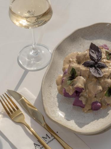 a plate of food next to a glass of wine at Olisa Praia Hotel in Maresias