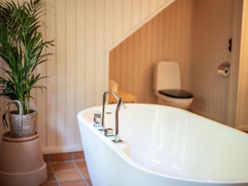 a bath tub with a plant in a bathroom at Åkagårdens Lodge in Båstad