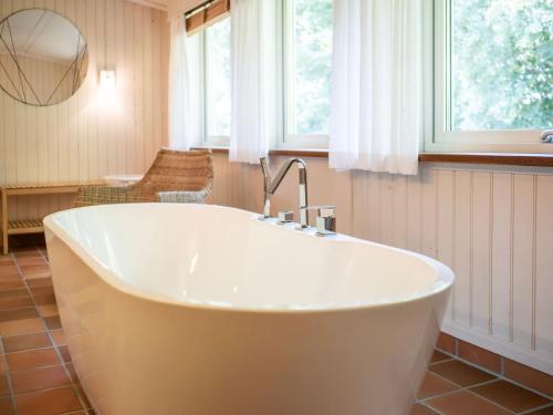 a bath tub in a bathroom with a window at Åkagårdens Lodge in Båstad