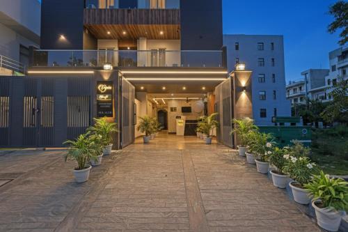 a building with potted plants on a sidewalk at FabHotel Grand Olive I in Noida