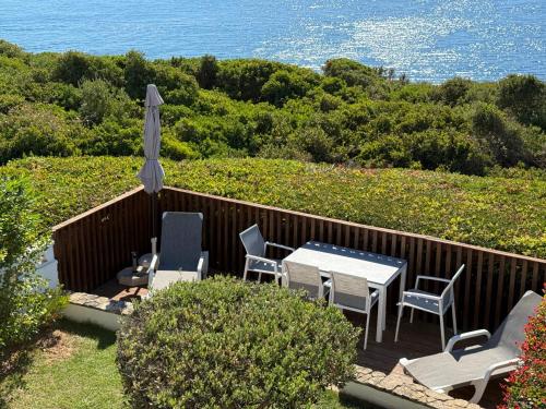a patio with a table and chairs and an umbrella at Casa Rosa Azul - Terracos de Benagil (Cliffside) in Benagil