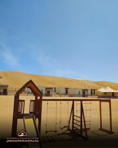a wooden chair sitting in the middle of a desert at Al Salam Desert Camp Bidiya in Bidiyah