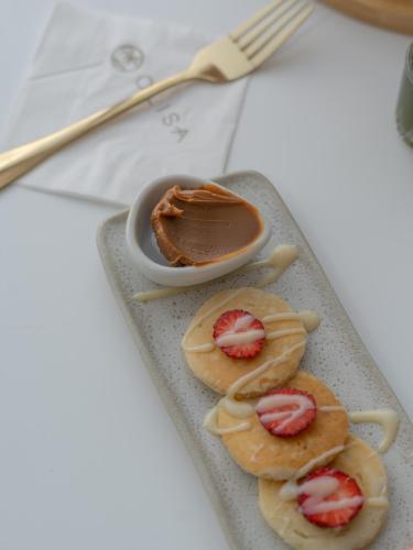 a plate with three cookies with strawberries and chocolate at Olisa Praia Hotel in Maresias