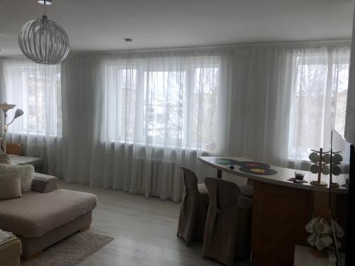 ein Wohnzimmer mit einem Tisch und einigen Fenstern in der Unterkunft Järveküla in Kohtla-Järve