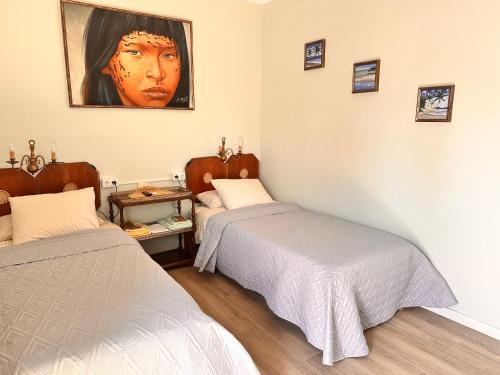 a bedroom with two beds and a painting on the wall at Villa IRI Habitación N 2 con un baño compartido , balcón in Pineda de Mar