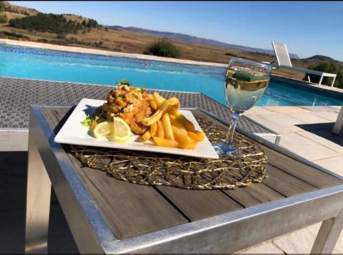 un plato de comida y una copa de vino en una mesa en Grace Lodging and Conference Centre, en Maseru