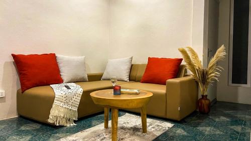 a couch with pillows and a table in a room at Serenity, Peace, Fulfilment all at one place in Pointe aux Piments