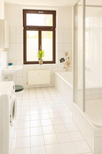 a white bathroom with a tub and a sink at TOP ANGEBOT - große Wohnung - max 6 Personen - WiFi - Waschmaschine - Badewanne - 2 Parkplätze - zentrale Lage - große Küche TOP in Chemnitz