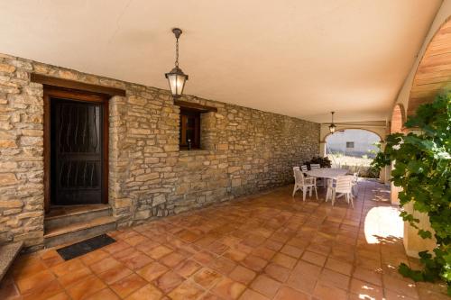 an indoor patio with a stone wall and a table at Casa Joan de Fontsagrada in Fontsagrada