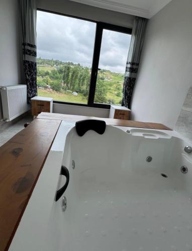 a bath tub in a room with a large window at Lina Apart in Arnavutköy