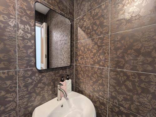un baño con lavabo y espejo en Simfoni Comfy Premium 09, en Kuah
