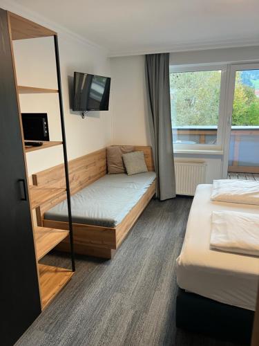 a hotel room with two beds and a tv at Wander- und Familienhotel Erika in Wagrain